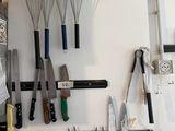 many kitchen utensils hanging on the wall