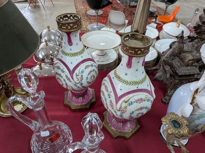 de nombreux vases posés sur une table recouverte d'une nappe rouge