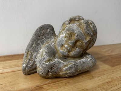 a small statue of an angel sitting on a wooden table