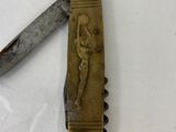 a knife that has a carving of a man on it