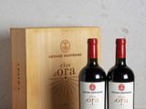 two bottles of red wine sitting next to a wooden box