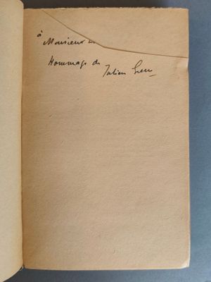 un livre ouvert avec une écriture dessus, posé sur une table