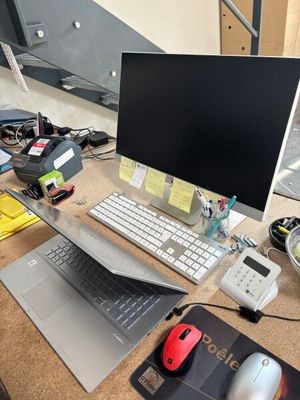 un bureau sur lequel se trouvent un ordinateur, un clavier, une souris et d'autres objets