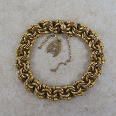 un gros plan d'un bracelet en chaîne dorée orné d'une feuille