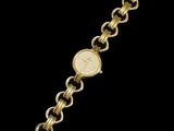 a gold plated wrist watch with a chain around it