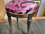 un tabouret rembourré orné d'un motif violet et noir