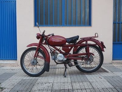 a red motorcycle parked in front of a building