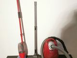 a red vacuum and a red vacuum cleaner on a green table