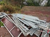 a pile of metal pipes and other items in a field
