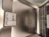 a dishwasher that is in the middle of a stainless steel sink