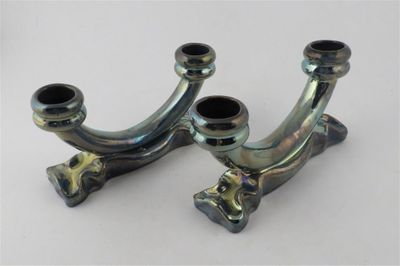pair of chrome plated metal pipe holders on a white surface
