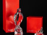 deux figurines en verre représentant une femme en robe rouge et une boîte rouge
