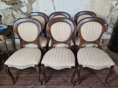 six chairs that are lined up on a wooden floor