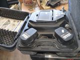 un étui noir contenant deux piles, posé sur une table