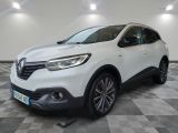 une voiture blanche est garée dans une grande pièce au sol en damier