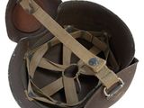 a brown helmet with a tan strap on top of it