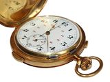 a gold pocket watch that is open on a white surface