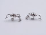 pair of silver plated earrings with flowers on them on a white surface