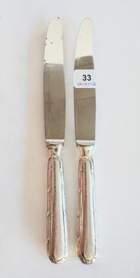 deux couteaux posés l'un à côté de l'autre sur une table