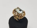 a gold ring with an emerald stone surrounded by filigree filigree