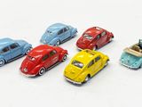 several toy cars are lined up in a row on a white surface
