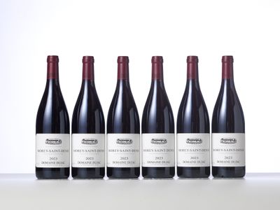 four bottles of wine are lined up on a table