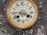 a marble clock with roman numerals on the face