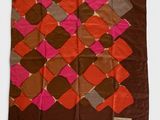 un gros plan d'une écharpe marron et rose sur fond blanc