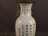 a white vase with asian writing on it on a table