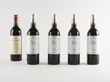 four bottles of wine are lined up on a white surface
