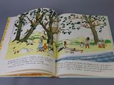 an open book with a picture of children playing in the park