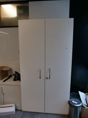 des placards dans une pièce où se trouvent une poubelle et une poubelle
