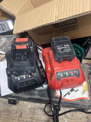 une boîte à outils posée sur une table à côté de deux perceuses