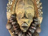 an image of a wooden mask hanging on a wall