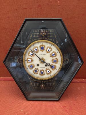 une horloge posée sur une table, à l'intérieur d'une vitrine