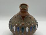 a small brown vase with blue and green designs on it