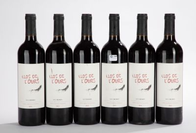 six bouteilles de vin sont alignées sur une surface blanche