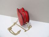 a red purse with a gold chain hanging from it