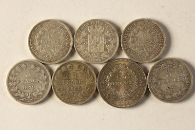 six pièces de monnaie britanniques différentes empilées les unes sur les autres sur une surface blanche