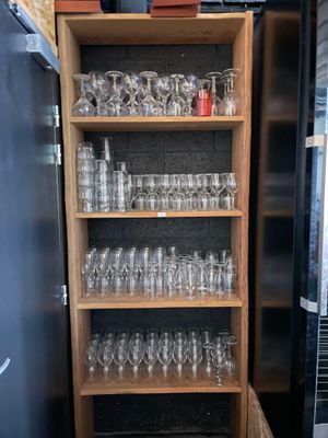 une grande étagère en bois remplie de verres et de verres à vin