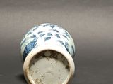 a small blue and white vase sitting on a table