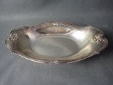 an antique silver plate on a table with a black background