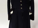 a black coat on a mannequin with a white shirt and black boots