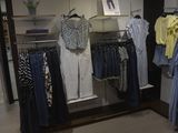 a lot of clothes hanging on a rack in a store