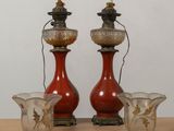 three vases sitting on a table with a lamp on top of them