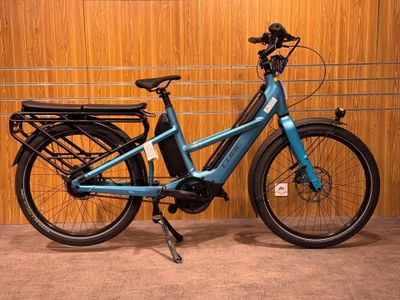 un vélo bleu garé dans un garage, avec un panier à l'arrière