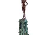 statue en bronze représentant une femme debout sur un rocher, les bras levés
