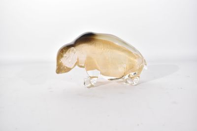 un objet en verre orné d'une coquille, posé sur une surface blanche