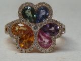 une photo en gros plan d'une bague sertie de pierres de différentes couleurs