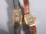 two watches sitting next to each other on a table